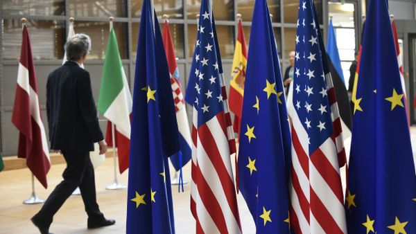 A man walks near US and European Union flags at the EU headquarters on May 15, 2017 in Brussels - Sputnik International