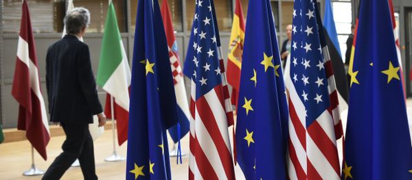 A man walks near US and European Union flags at the EU headquarters on May 15, 2017 in Brussels - Sputnik International