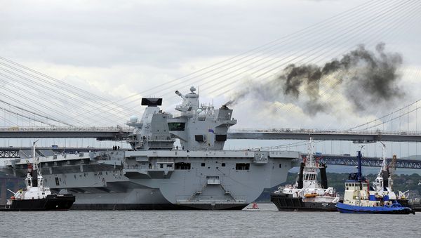 Tug boats manoeuvre the 65,000-tonne British aircraft carrier HMS Queen Elizabeth on the Firth of Forth in east Scotland, on June 26, 2016, after escorting it out of its berth in Rosyth Naval dockyard to begin sea trials. - Sputnik International