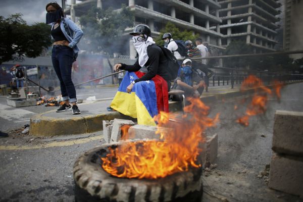Masked anti-government demonstrators stend to a burning barricade during a protest against the installation of a constitutional assembly in Caracas, Venezuela, Friday, Aug. 4, 2017 - Sputnik International