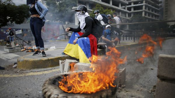 Masked anti-government demonstrators stend to a burning barricade during a protest against the installation of a constitutional assembly in Caracas, Venezuela, Friday, Aug. 4, 2017 Masked anti-government demonstrators stend to a burning barricade during a protest against the installation of a constitutional assembly in Caracas, Venezuela, Friday, Aug. 4, 2017 - Sputnik International