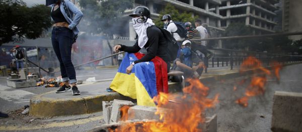 Masked anti-government demonstrators stend to a burning barricade during a protest against the installation of a constitutional assembly in Caracas, Venezuela, Friday, Aug. 4, 2017 Masked anti-government demonstrators stend to a burning barricade during a protest against the installation of a constitutional assembly in Caracas, Venezuela, Friday, Aug. 4, 2017 - Sputnik International