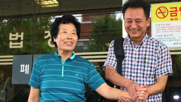 Lee Kyung-Ja (L), a relative of late victim Choe Jeong-Rye, and Lee Kuk-Un (R), who leads a group of activists working for former slave workers, react outside the district court in the southern city of Gwangju on August 8, 2017 after the court ruled Mitsubishi Heavy Industries should pay compensation to two South Korean former wartime slave workers - Sputnik International