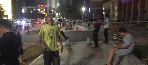 People stand outside buildings after an earthquake was felt in Xian in central China's Shanxi province on August 8, 2017 - Sputnik International