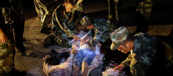 Chinese paramilitary police take care of a survivor after an earthquake in Jiuzhaigou county, Ngawa prefecture, Sichuan province, China August 9, 2017 - Sputnik International