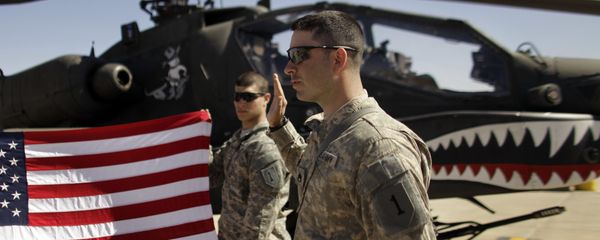 In this March 16, 2011, file photo Army Staff Sgt. Christopher Seeman, right, of Kalispell, Mont., takes the oath of re-enlistment as Spc. Brian Martinez, center, of Aurora, Ill., holds up a American flag in front of an Apache helicopter during a ceremony at Camp Taji, north of Baghdad, Iraq. In this March 16, 2011, file photo Army Staff Sgt. Christopher Seeman, right, of Kalispell, Mont., takes the oath of re-enlistment as Spc. Brian Martinez, center, of Aurora, Ill., holds up a American flag in front of an Apache helicopter during a ceremony at Camp Taji, north of Baghdad, Iraq. - Sputnik International