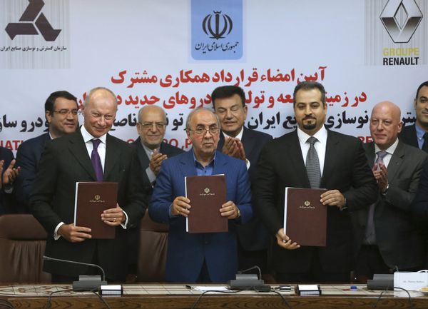 Chief Competitive Officer of Groupe Renault Thierry Bolloré, left, Chairman of Industrial Development and Renovation Oraganization of Iran, IDRO, Mansour Moazami, center, and Negin Group CEO Kourosh Morshed Solouk join shows documents to media after signing a deal in Tehran, Iran, Monday, Aug. 7, 2017 - Sputnik International