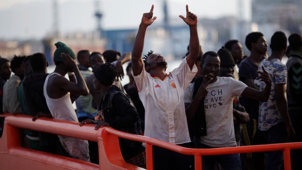 A migrant, who is part of a group intercepted aboard a dinghy off the coast in the Mediterranean sea, reacts on a rescue boat upon arriving at a port in Malaga, Spain August 7, 2017 - Sputnik International