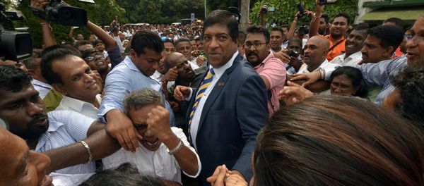 Sri Lanka's foreign minister Ravi Karunanayake reacts as he is surrounded by his supporters after he resigned on Thursday over corruption charges, in Colombo, Sri Lanka August 10, 2017 - Sputnik International