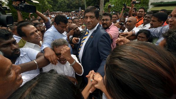 Sri Lanka's foreign minister Ravi Karunanayake reacts as he is surrounded by his supporters after he resigned on Thursday over corruption charges, in Colombo, Sri Lanka August 10, 2017 Sri Lanka's foreign minister Ravi Karunanayake reacts as he is surrounded by his supporters after he resigned on Thursday over corruption charges, in Colombo, Sri Lanka August 10, 2017 - Sputnik International