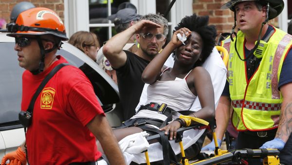 Rescue personnel help an injured woman after a car ran into a large group of protesters after an white nationalist rally in Charlottesville, Va., Saturday, Aug. 12, 2017. Rescue personnel help an injured woman after a car ran into a large group of protesters after an white nationalist rally in Charlottesville, Va., Saturday, Aug. 12, 2017. - Sputnik International