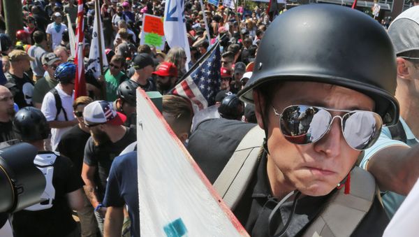 A white nationalist demonstrator with a helmet and shield walks into Lee Park in Charlottesville, Va., Saturday, Aug. 12, 2017. Hundreds of people chanted, threw punches, hurled water bottles and unleashed chemical sprays on each other Saturday after violence erupted at a white nationalist rally in Virginia. - Sputnik International