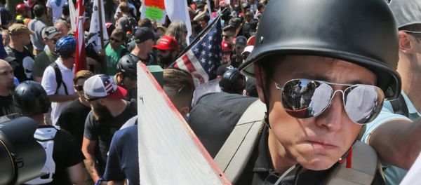 A white nationalist demonstrator with a helmet and shield walks into Lee Park in Charlottesville, Va., Saturday, Aug. 12, 2017. Hundreds of people chanted, threw punches, hurled water bottles and unleashed chemical sprays on each other Saturday after violence erupted at a white nationalist rally in Virginia. A white nationalist demonstrator with a helmet and shield walks into Lee Park in Charlottesville, Va., Saturday, Aug. 12, 2017. Hundreds of people chanted, threw punches, hurled water bottles and unleashed chemical sprays on each other Saturday after violence erupted at a white nationalist rally in Virginia. - Sputnik International