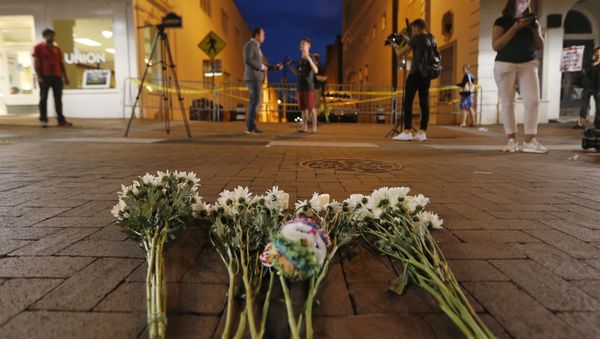 Flowers and other mementos are left at a makeshift memorial for the victims after a car plowed into a crowd of people peacefully protesting a white nationalist rally earlier in the day in Charlottesville, Va., Saturday, Aug. 12, 2017. (AP - Sputnik International