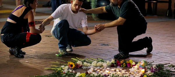 Two people stop to comfort a man as he kneels at a late night vigil to pay his respect for a friend injured in a car attack on counter protesters after a march organized by white nationalists in Charlottesville, Virginia, U.S., August 12, 2017 Two people stop to comfort a man as he kneels at a late night vigil to pay his respect for a friend injured in a car attack on counter protesters after a march organized by white nationalists in Charlottesville, Virginia, U.S., August 12, 2017 - Sputnik International