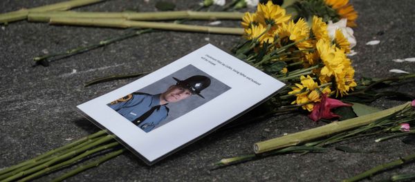 A photo of one of two Virginia state troopers killed in a helicopter crash lies among flowers at a makeshift memorial at the scene of where a car plowed into counter-protesters in Charlottesville, Virginia A photo of one of two Virginia state troopers killed in a helicopter crash lies among flowers at a makeshift memorial at the scene of where a car plowed into counter-protesters in Charlottesville, Virginia - Sputnik International