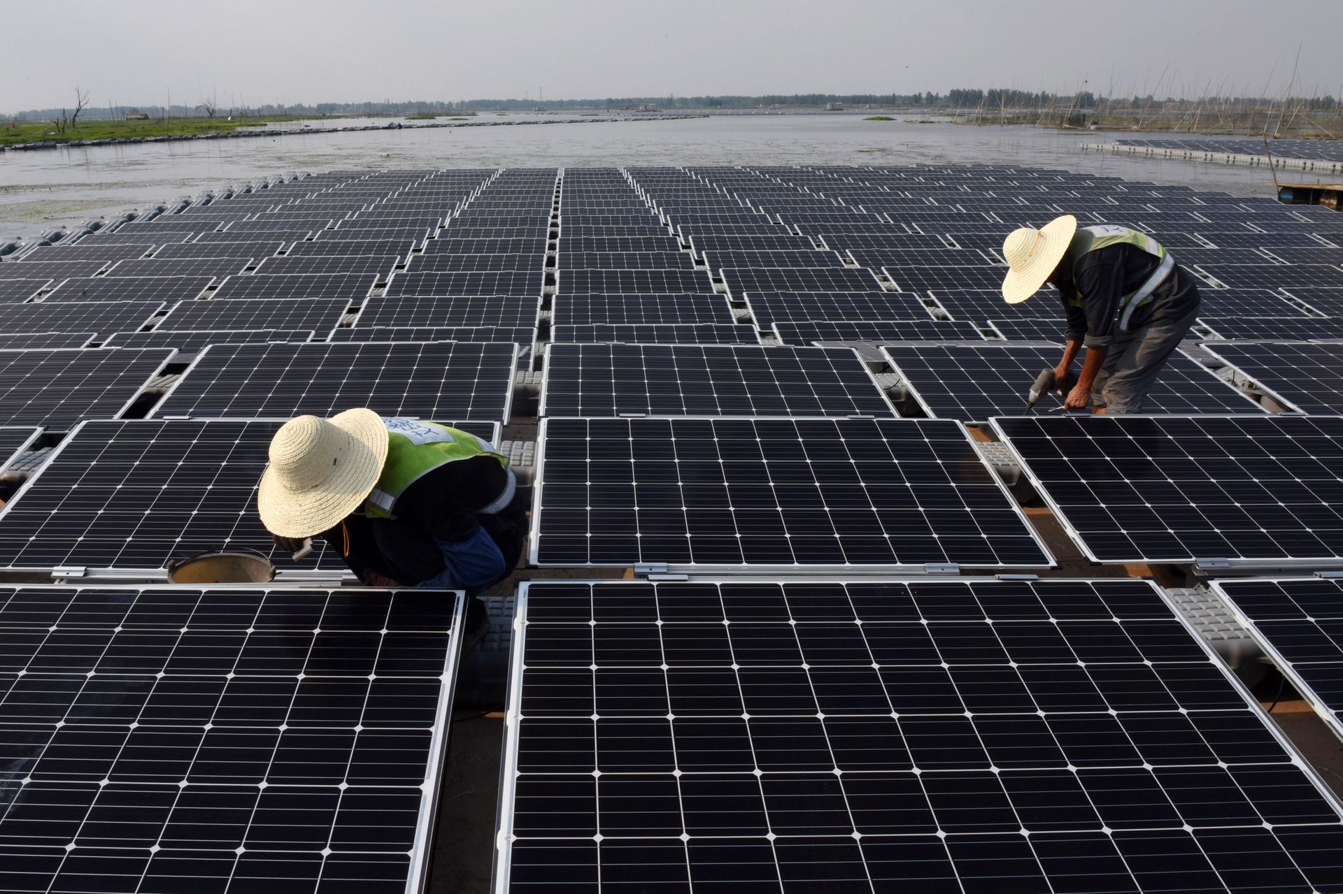 This photo taken on June 7, 2017 shows workers at the world's largest floating solar power plant in a lake in Huainan, in China's central Anhui province This photo taken on June 7, 2017 shows workers at the world's largest floating solar power plant in a lake in Huainan, in China's central Anhui province - Sputnik International, 1920, 11.11.2021
