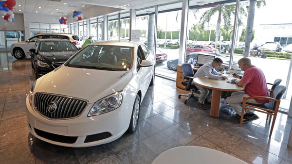 In this Wednesday, April 26, 2017, photo, client specialist Felipe A. Perdomo, left, closes a deal with customer John Tsialas at a GMC Buick dealership in Miam - Sputnik International