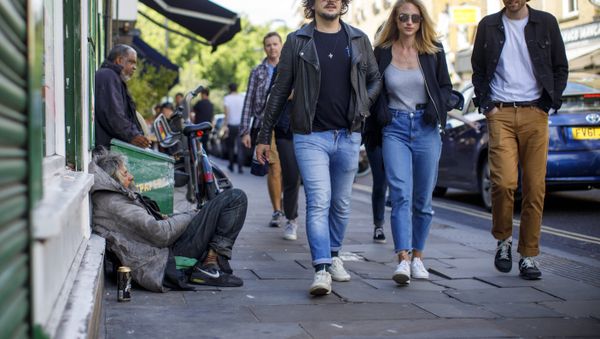 A group of people walks past homeless people on Broadway Market in east London on July 23, 2017 - Sputnik International