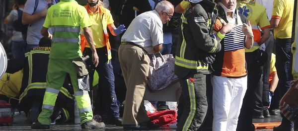 Injured people are treated in Barcelona, Spain, Thursday, Aug. 17, 2017 after a white van jumped the sidewalk in the historic Las Ramblas district, crashing into a summer crowd of residents and tourists and injuring several people, police said. - Sputnik International