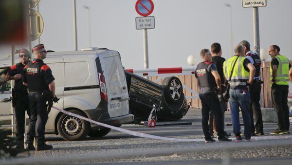 A police officer walks near an overturned car at the spot where terrorists were intercepted by police in Cambrils, Spain, Friday, Aug. 18, 2017 - Sputnik International