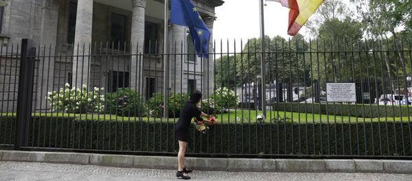 The Spanish and the European flag fly at half mast as a woman fixes flowers at the fence of the Spanish embassy in Berlin, on August 18, 2017 in tribute to victims of the Barcelona attack The Spanish and the European flag fly at half mast as a woman fixes flowers at the fence of the Spanish embassy in Berlin, on August 18, 2017 in tribute to victims of the Barcelona attack - Sputnik International