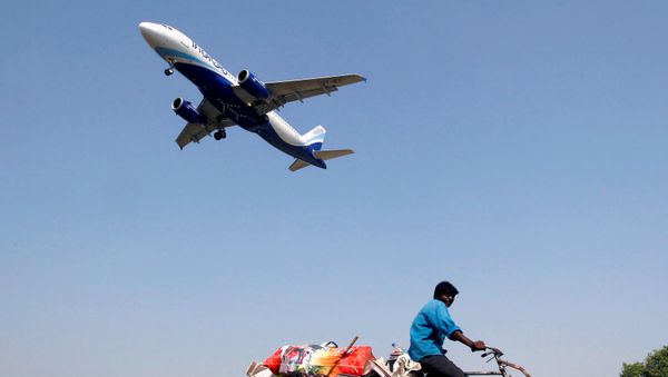 An IndiGo Airlines aircraft prepares to land as a man paddles his cycle rickshaw in Ahmedabad, India, October 26, 2015 - Sputnik International