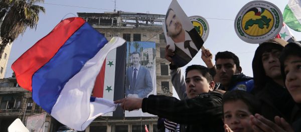 Pro-government supporters wave the Russian national flag and pictures of Syrian President Bashar Assad, as gathering at the Saadallah al-Jabiri Square in Aleppo, Syria, Thursday, Jan. 19, 2017 - Sputnik International