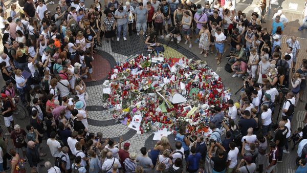 People gather at a memorial tribute of flowers, messages and candles to the victims on Barcelona's historic Las Ramblas promenade on the Joan Miro mosaic, embedded in the pavement where the van stopped after killing at least 13 people in Barcelona , Spain, Friday, Aug. 18, 2017 - Sputnik International