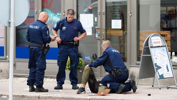 Police officers stand next to a person lying on the pavement in the Finnish city of Turku where several people were stabbed on August 18, 2017 - Sputnik International