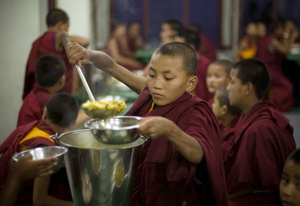 A young Buddhist monk serves food during dinner at the Kopan Monastery in Katmandu, Nepal. (File) - Sputnik International
