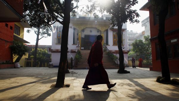 A Tibetan monk walks inside a deserted Tibetan Monastery at Boudhanath Stupa in Katmandu, Nepal. (File) A Tibetan monk walks inside a deserted Tibetan Monastery at Boudhanath Stupa in Katmandu, Nepal. (File) - Sputnik International