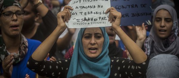 A woman holds a banner reading in Spanish: I am Muslim and Catalan, not a terrorist. Islam is Peace, during a protest by the Muslim community to condemn the vehicle attacks, in Barcelona, Spain A woman holds a banner reading in Spanish: I am Muslim and Catalan, not a terrorist. Islam is Peace, during a protest by the Muslim community to condemn the vehicle attacks, in Barcelona, Spain - Sputnik International