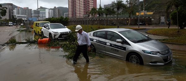 A man wades through floodwaters away from his car after heavy rains brought on by Typhoon Hato in Hong Kong on August 23, 2017 - Sputnik International