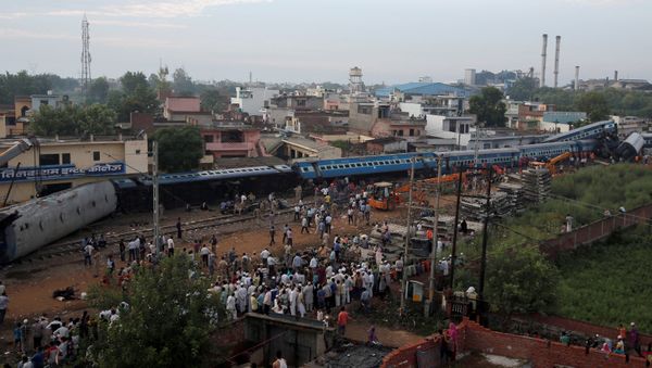 Rescue workers and onlookers stand next to derailed coaches of a passenger train at the site of an accident in Khatauli, in the northern state of Uttar Pradesh, India August 20, 2017 - Sputnik International