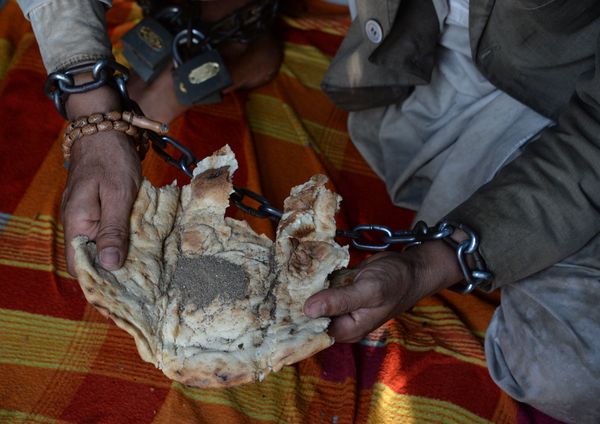 In this photograph taken on May 2, 2017, a mentally ill Afghan patient has his lunch of bread and black pepper as he sits chained to a wall at the Mia Ali Baba holy shrine in the village of Samar Khel on the outskirts of Jalalabad In this photograph taken on May 2, 2017, a mentally ill Afghan patient has his lunch of bread and black pepper as he sits chained to a wall at the Mia Ali Baba holy shrine in the village of Samar Khel on the outskirts of Jalalabad - Sputnik International