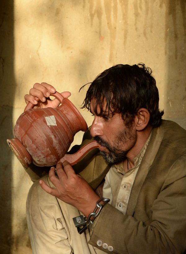 In this photograph taken on May 7, 2017, a mentally ill Afghan patient drinks water as he sits chained to a wall at the Mia Ali Baba holy shrine in the village of Samar Khel on the outskirts of Jalalabad In this photograph taken on May 7, 2017, a mentally ill Afghan patient drinks water as he sits chained to a wall at the Mia Ali Baba holy shrine in the village of Samar Khel on the outskirts of Jalalabad - Sputnik International