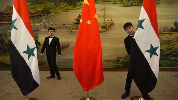 Attendants adjust Syrian and Chinese flags before a briefing at China's Ministry of Foreign Affairs in Beijing, Thursday, Dec. 24, 2015 - Sputnik International