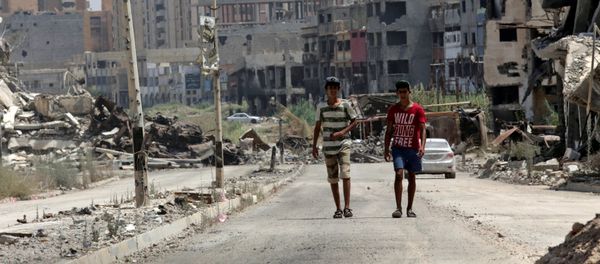 Men walk near destroyed buildings in Sabri, a central Benghazi district, Libya, August 12, 2017 - Sputnik International
