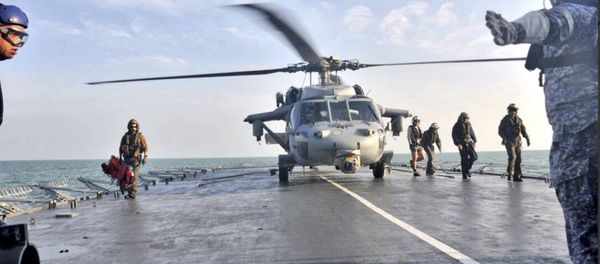 In this photo released by the Royal Malaysian Navy, a U.S. Navy helicopter lands to receive an unidentified body recovered by the Royal Malaysian Navy off the Johor coast of Malaysia, Wednesday, Aug. 23, 2017 - Sputnik International
