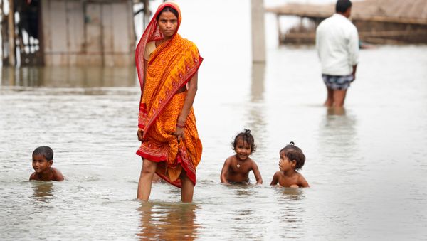 A woman walks through a flooded village in Motihari, Bihar State, India August 23, 2017. A woman walks through a flooded village in Motihari, Bihar State, India August 23, 2017. - Sputnik International