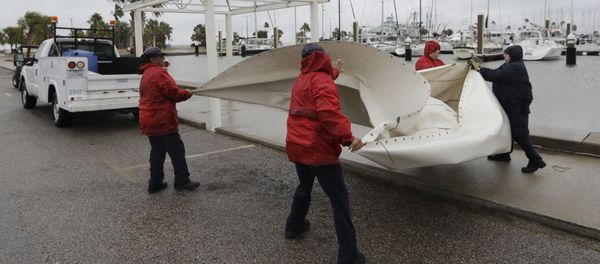 City workers pull down a canvas covering as the outer bands of Hurricane Harvey move closer, Friday, Aug. 25, 2017, in Corpus Christi, Texas - Sputnik International