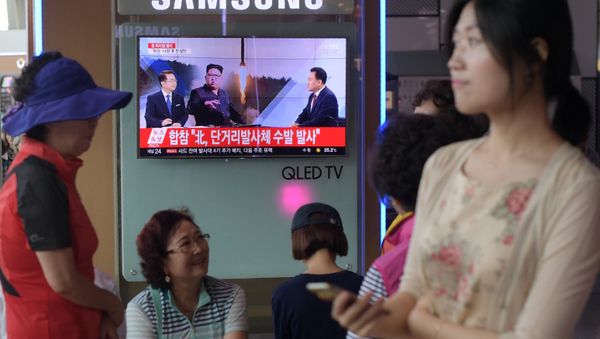 People are seen past a television screen showing a file image of North Korean leader Kim Jong-Un (C) as news anchors (on screen, L and R) provide coverage of this morning's North Korean missile launch, at a railway station in Seoul on August 26, 2017 People are seen past a television screen showing a file image of North Korean leader Kim Jong-Un (C) as news anchors (on screen, L and R) provide coverage of this morning's North Korean missile launch, at a railway station in Seoul on August 26, 2017 - Sputnik International