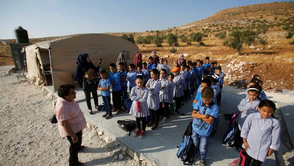 Palestinian schoolchildren queue outside a tent where they attend lessons after Israeli troops confiscated caravans used as school classrooms, due to the lack of an Israeli-issued construction permit, in the West Bank village of Jubbet Al Dhib, near Bethlehem August 24, 2017 - Sputnik International