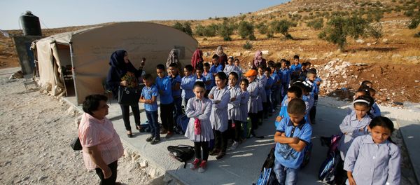 Palestinian schoolchildren queue outside a tent where they attend lessons after Israeli troops confiscated caravans used as school classrooms, due to the lack of an Israeli-issued construction permit, in the West Bank village of Jubbet Al Dhib, near Bethlehem August 24, 2017 - Sputnik International