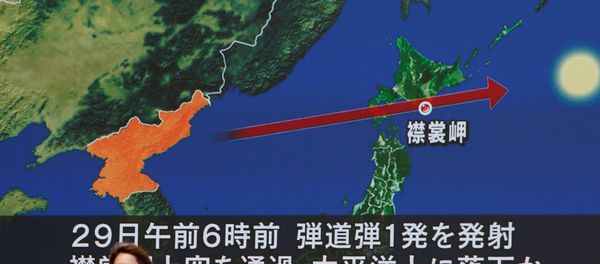 A woman walks past a large TV screen showing news about North Korea's missile launch in Tokyo, Japan, August 29, 2017. - Sputnik International