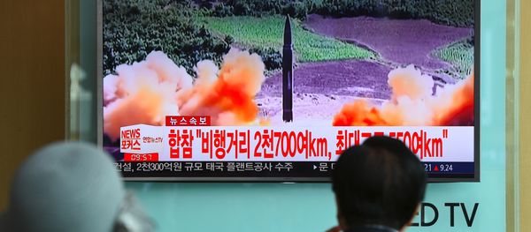 People watch a television news screen showing file footage of a North Korean missile launch, at a railway station in Seoul on August 29, 2017. - Sputnik International