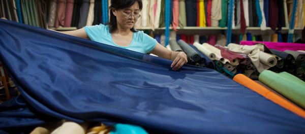 A vendor prepares rolls of silk at her textile and fabric shop in Beijing A vendor prepares rolls of silk at her textile and fabric shop in Beijing - Sputnik International