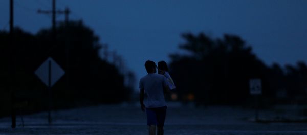 Ethan holds his 2-year-old daughter Zella as they walk through flood waters from Tropical Storm Harvey in Iowa, Calcasieu Parish, Louisiana, U.S Ethan holds his 2-year-old daughter Zella as they walk through flood waters from Tropical Storm Harvey in Iowa, Calcasieu Parish, Louisiana, U.S - Sputnik International