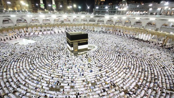 Muslim worshippers perform the evening (Isha) prayers at the Kaaba, Islam's holiest shrine, at the Grand Mosque in Saudi Arabia's holy city of Mecca on August 25, 2017, a week prior to the start of the annual Hajj pilgrimage in the holy city   - Sputnik International